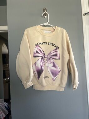 Zara Cream Crewneck Sweatshirt with Purple Bow Graphic
